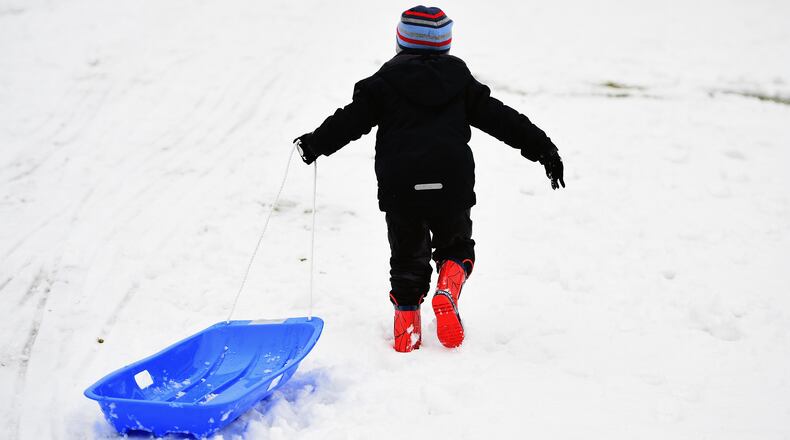 A boy pulls his sled in a 2015 photo. A Baltimore, Maryland, man was killed and his young son critically injured Dec. 17, 2016, when they were struck by a vehicle while sledding down a driveway.  (Jeff J. Mitchell/Getty Images)