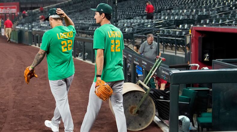 Athletics' Tommy White, left, and Alika Williams wear a Lasko No. 22 t-shirt in honor of injured Athletics minor league player Ryan Lasko prior to a baseball game against the Arizona Diamondbacks, Wednesday, July 22, 2026, in Phoenix. (AP Photo/Ross D. Franklin)