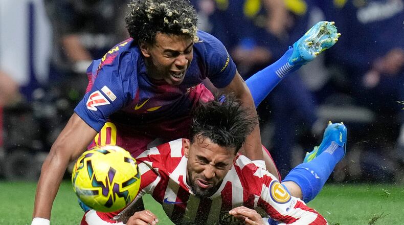 Barcelona's Lamine Yamal, top, is tackled and fouled by Atletico Madrid's Nico Gonzalez, who receives a second yellow card and is then sent off during a La Liga soccer match between Atletico Madrid and Barcelona in Madrid, Spain, Saturday, April 4, 2026. (AP Photo/Bernat Armangue)