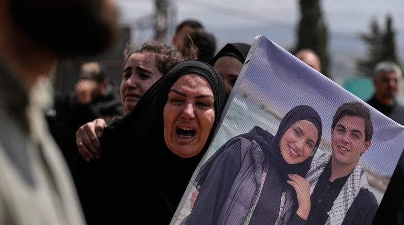A woman mourns during a mass funeral for Hezbollah fighters and civilians who were killed in the war between Hezbollah and Israel, in Bazouriyeh village, south Lebanon, Monday, April 20, 2026. (AP Photo/Mohammed Zaatari)c