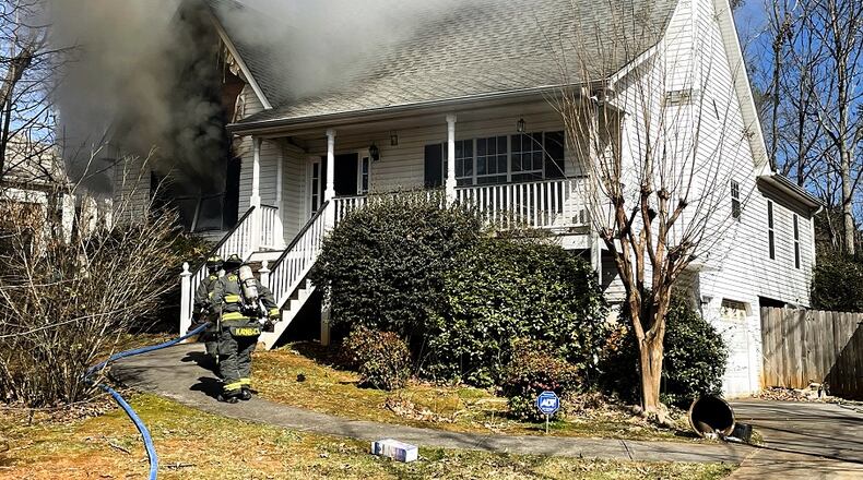 A 60-year-old woman died after being pulled from her burning home Sunday morning, the Cherokee County fire department said.