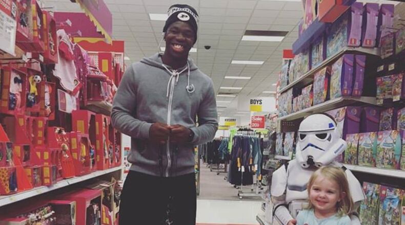 Tario Fuller, a football player at Purdue University and Gwinnett native, with a doll he bought for two-year-old Kinley for her birthday at a Target in Indiana. Photo by Megan Shufflebarger.