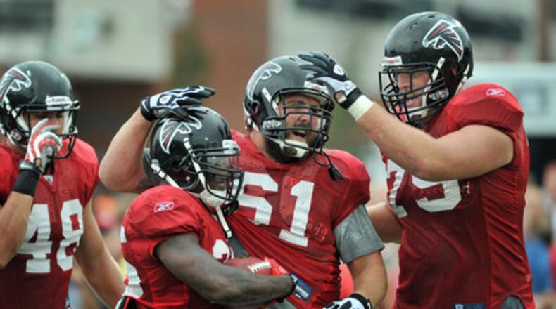 Atlanta Falcons's Antone Smith (second from left, 35) is congratulated by his teammates Joe Hawley (61) and Garrett Reynolds (75) during the Friday Night Lights at North Gwinnett High School in Suwanee. Hyosub Shin hshin@ajc.com