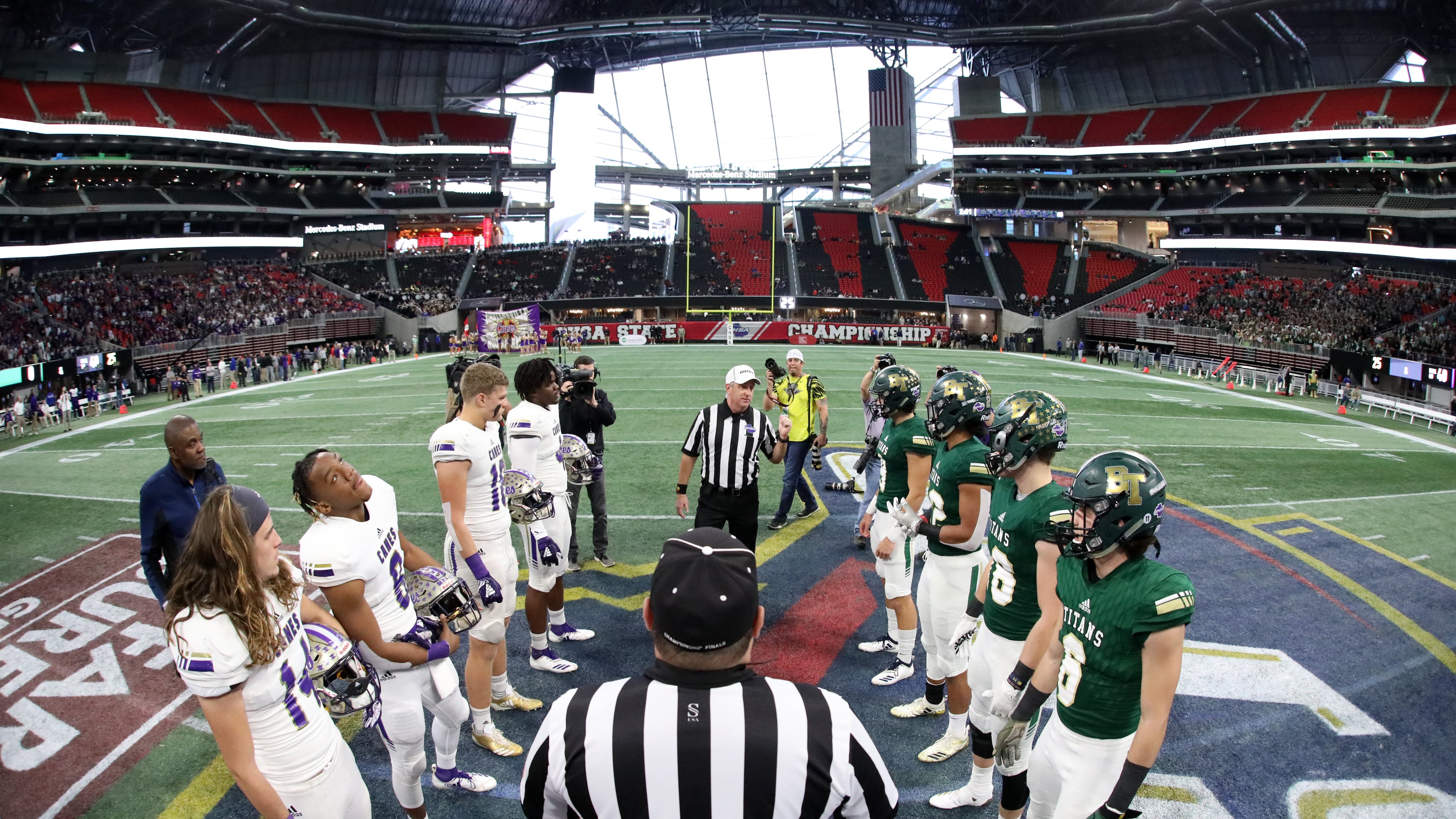 Cartersville players (left) and Blessed Trinity players participate in the coin toss with officials before the start of the Class AAAA State Championship game at Mercedes-Benz Stadium in Atlanta. (Jason Getz/AJC 2018)