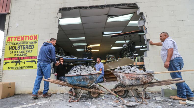 Workers with N.B. Masonry worked to fix a hole at Gable Sporting Goods in Douglasville.