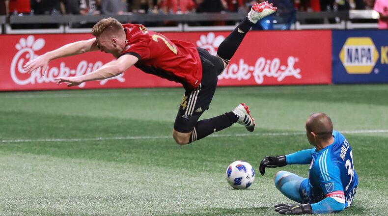 Atlanta United midfielder Julian Gressel is sent flying in a collision with New York Red Bulls goalkeeper Luis Robles during the Eastern Conference finals Sunday, Nov. 25, 2018, in Atlanta.