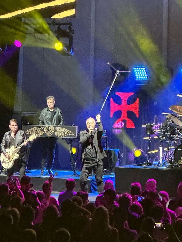 Jim Kerr of Simple Minds twirls his mic stand during the band's appearance at a nearly sold-out Synovus Bank Amphitheater at Chastain Park on Saturday. (Rodney Ho/AJC)