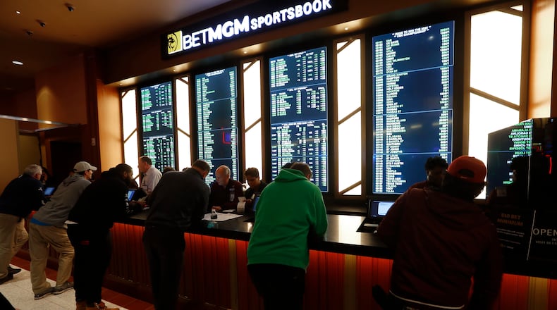 Gamblers place bets during the launch of legalized sports betting in Michigan at the MGM Grand Detroit casino in Detroit, Wednesday, March 11, 2020. As the bright lights of sports betting have gone dim, gamblers have been forced to find some imaginative alternatives.