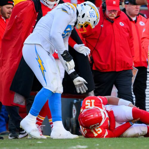 Los Angeles Chargers defensive tackle Justin Eboigbe (92) checks on Kansas City Chiefs quarterback Patrick Mahomes (15) as Chiefs head coach Andy Reid, center, looks on after Mahomes was injured during the second half of an NFL football game, Sunday, Dec. 14, 2025 in Kansas City, Mo. (AP Photo/Reed Hoffmann)