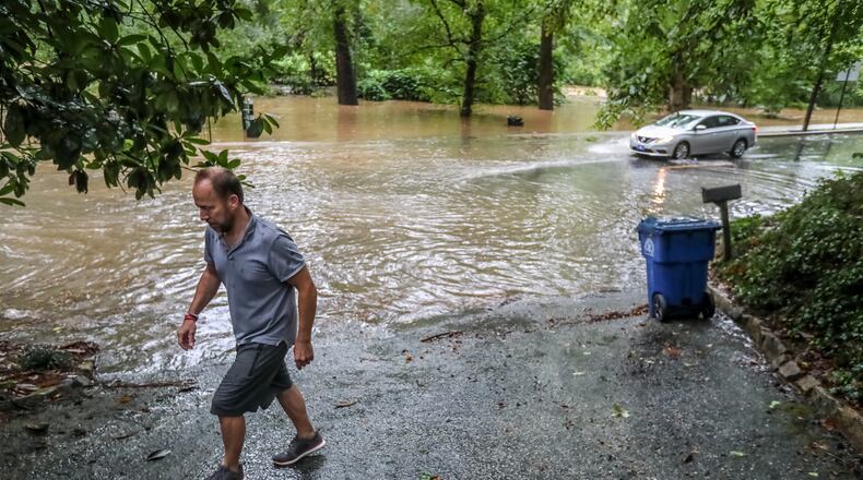 September 17, 2020 Atlanta: Peter Von Wismar walks back up his driveway after putting the recyclables out curbside where Peachtree Battle had to be closed at Woodward Way after Peachtree Creek rose from its banks in Atlanta. Remnants of Hurricane Sally, that downgraded to a tropical depression, moved through North Georgia on Thursday, Sept. 17, 2020. Heavy rain and flooding brought trees down and made a mess of the Thursday morning commute and knocked out power to thousands. By mid-day, Fulton, DeKalb and Gwinnett counties received between 2 and 4 inches of rain, and the Southside, between 1 and 3 inches. Areas like this would be identified in Fulton's updated Hazard Mitigation Plan. (John Spink / John.Spink@ajc.com)