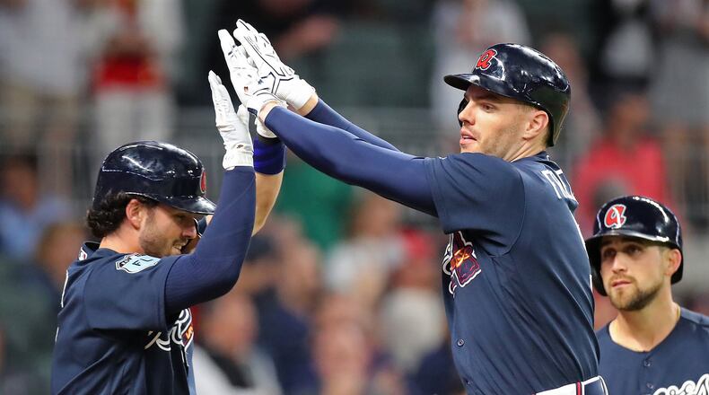 Braves rookie Dansby Swanson (left) congratulates Freddie Freeman after Freeman’s three-run homer gave the Braves a 3-2 lead over the New York Yankees in an exhibition game March 31, the Braves’ only game at SunTrust Park prior to Friday night’s home opener against the Padres. (Curtis Compton/ccompton@ajc.com)