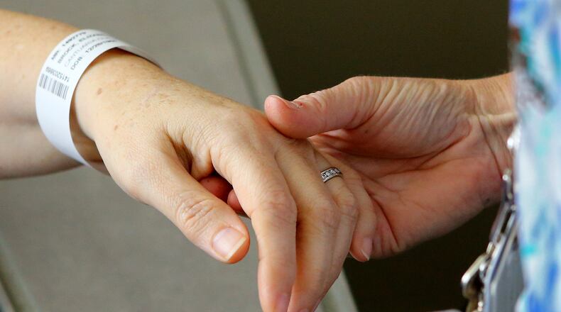 A nurse checks on a patient who has ovarian cancer before beginning her chemotherapy treatment. (PHOTO by CURTIS COMPTON / CCOMPTON@AJC.COM)