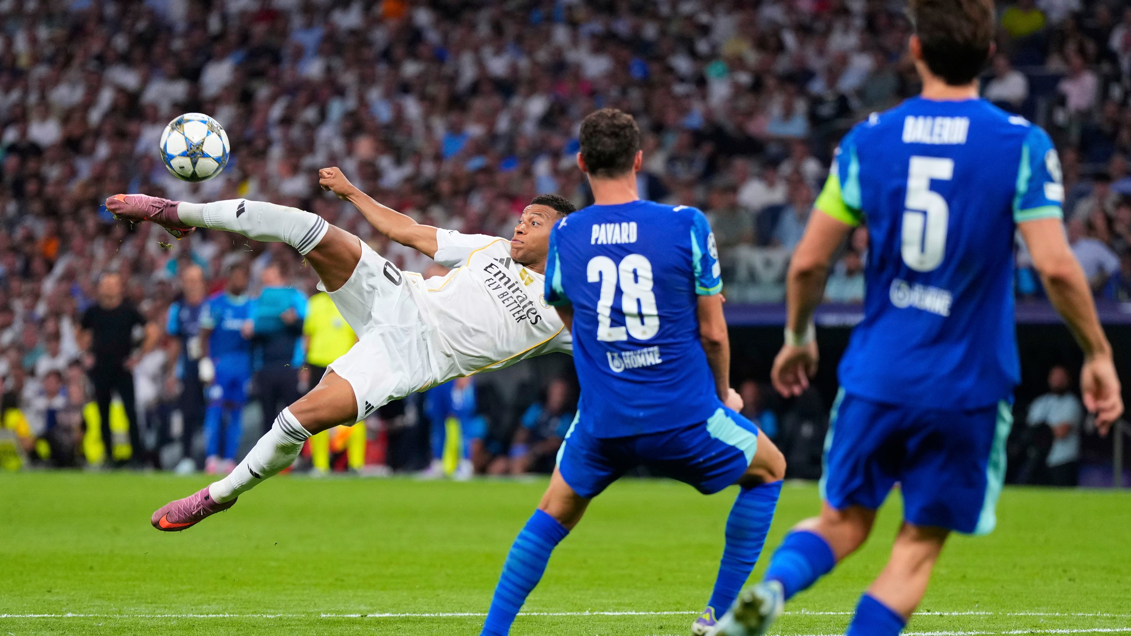 Real Madrid's Kylian Mbappe, left, shoots a high ball next to Marseille defenders during a Champions League opening phase soccer match between Real Madrid and Marseille at Santiago Bernabeu stadium, in Madrid, Tuesday, Sept. 16, 2025. (AP Photo/Manu Fernandez)