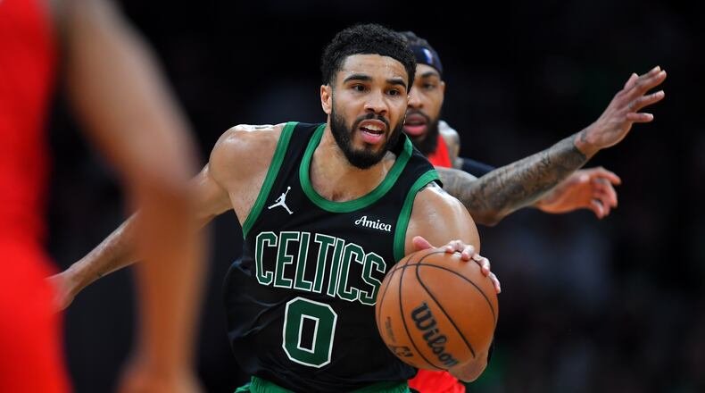 Boston Celtics forward Jayson Tatum (0) drives with the ball in front of Toronto Raptors forward Brandon Ingram in the second half of an NBA basketball game, Sunday, April 5, 2026, in Boston. (AP Photo/Steven Senne)
