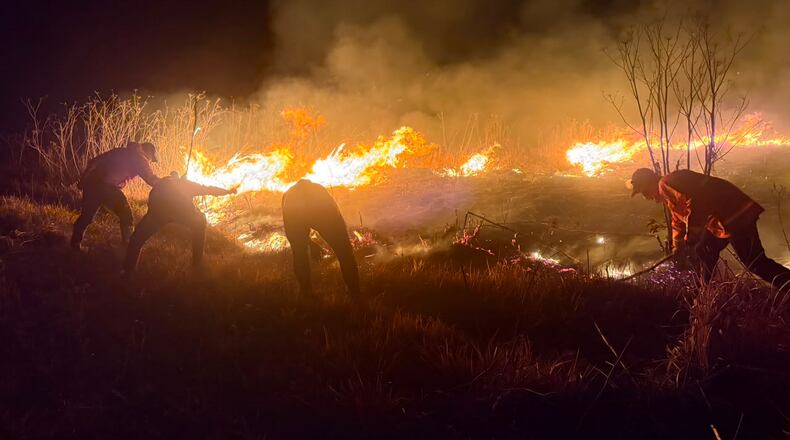In this photo released by the East Java Regional Disaster Mitigation Agency, firefighters attempt to extinguish a wildfire that razes through Mount Bromo National Park in Probolinggo, Indonesia on Saturday, Aug. 8, 2026. (East Java Regional Disaster Mitigation Agency via AP)