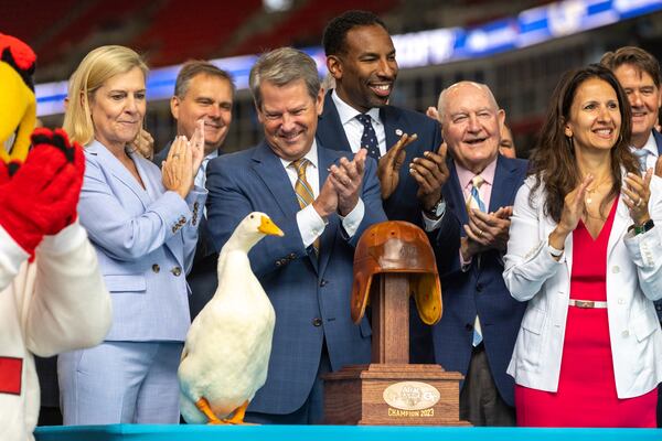 Gov. Brian Kemp (looking down at duck) joins the Aflac duck and others after ringing the New York Stock Exchange opening bell from Mercedes-Benz Stadium in Atlanta ahead of the inaugural Aflac Kickoff Game in 2023. It was the first time the NYSE opening bell had been rung from the state of Georgia. (Arvin Temkar/AJC 2023)