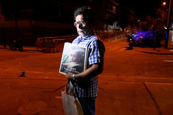 Gabriel Rimachi holds an issue of the literary magazine he directs, dedicated to Peruvian Nobel literature laureate Mario Vargas Llosa, after the announcement of the writer's death at the age of 89, in front of his home in Lima, Peru, Sunday, April 13, 2025. (AP Photo/Martin Mejia)