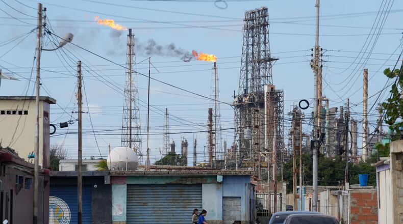 Flames rise from flare stacks at the Amuay refinery in Los Taques, Venezuela, Wednesday, Jan. 14, 2026. (AP Photo/Matias Delacroix)