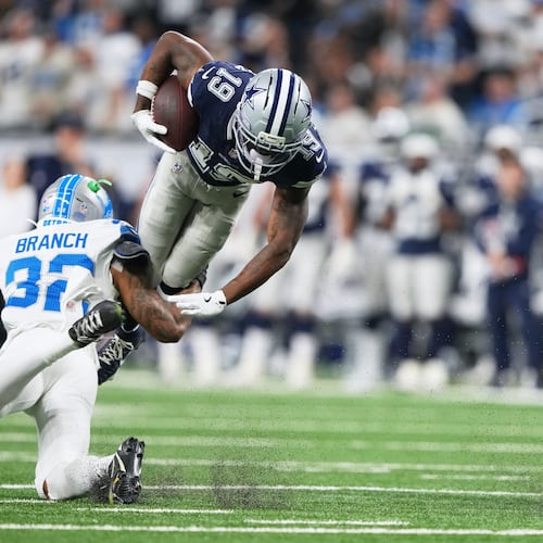 Dallas Cowboys wide receiver Ryan Flournoy (19) takes a hit from Detroit Lions safety Brian Branch (32) during the second half of an NFL football game Thursday, Dec. 4, 2025, in Detroit. (AP Photo/Ryan Sun)