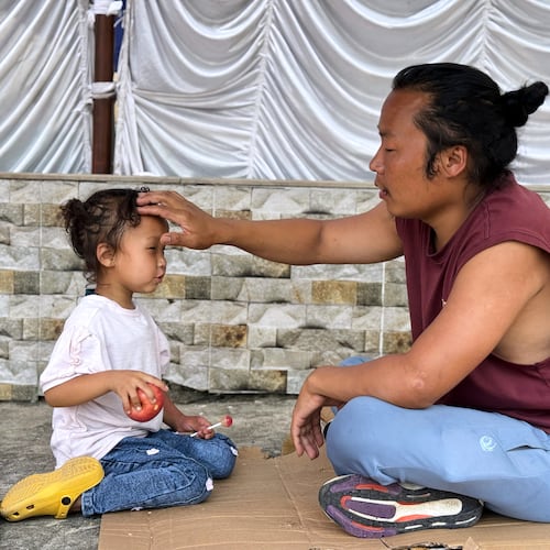 Survivor Tsering Gelbu Lama sits with his daughter at a monastery in Kathmandu, Nepal, Monday, Aug. 31, 2026. (AP Photo/Niranjan Shrestha)