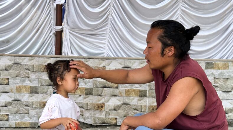 Survivor Tsering Gelbu Lama sits with his daughter at a monastery in Kathmandu, Nepal, Monday, Aug. 31, 2026. (AP Photo/Niranjan Shrestha)