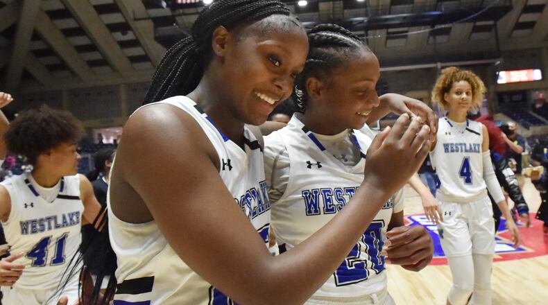 Westlake players Raven Johnson (25) and Ta’Niya Latson (20) walk off the court in celebration of their latest state title - a 64-46 victory over Carrollton - in the 6A girls championship game Friday, March 12, 2021, in Macon. (Hyosub Shin/hyosub.shin@ajc.com)