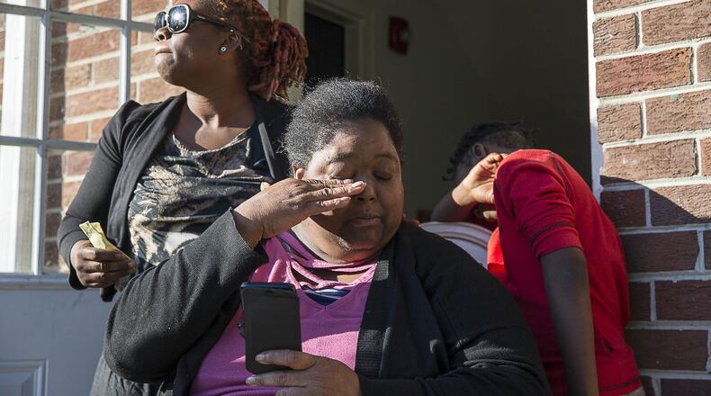 La-Raesha Steward (left) comforts Sonja D. Harrison (center) as she becomes emotional Tuesday while looking at photos of her daughter, Sonja “Star” Harrison, at the Pavilion Place apartments in Atlanta’s Hammond Park community. (ALYSSA POINTER/ALYSSA.POINTER@AJC.COM)