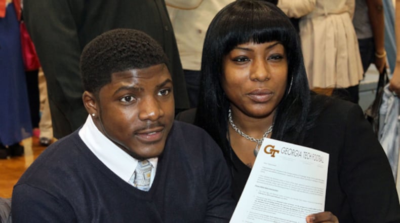 Char Custis watches as her son, Lovejoy running back Travis Custis, holds up his commitment letter to Georgia Tech in the Lovejoy High School gymnasium in Hampton. The 6-foot, 205-pound running back had a breakout senior season: rushing for 2,058 yards and 35 touchdowns while leading Lovejoy to the state championship game for the second year in a row.