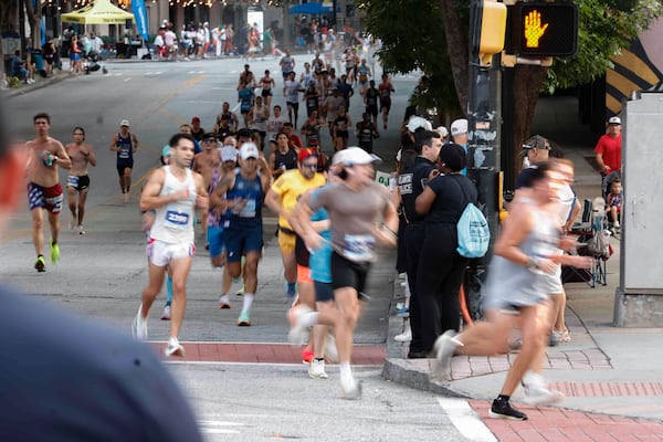Runners turn to corner on 10th Street to complete the last mile of the 2025 AJC Peachtree Road Race on Friday, July 4, 2025. (Natrice Miller/AJC)