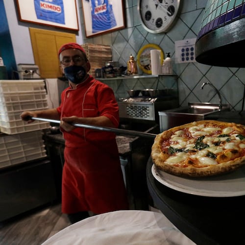 FILE -Eugenio Iorio bakes a pizza at a restaurant in Naples, Italy, Saturday, Nov. 14, 2020. (AP Photo/Gregorio Borgia, File)