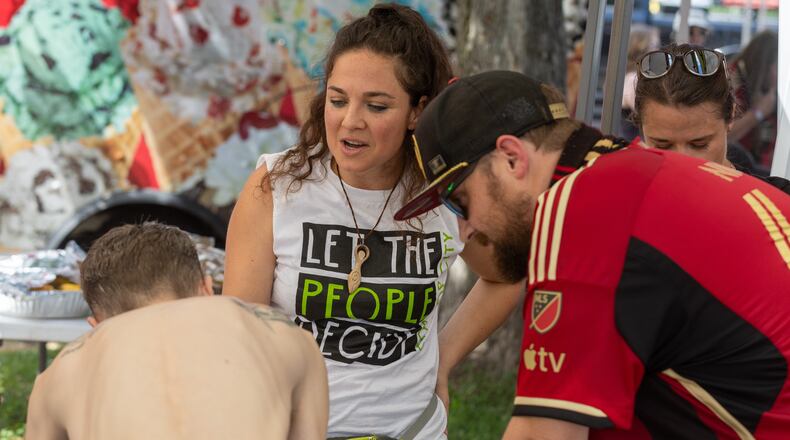 Cop City Vote Coalition volunteer Misty Novitch helps gather referendum petition signatures before the Atlanta United game Saturday, July 15, 2023.   (Steve Schaefer/steve.schaefer@ajc.com)