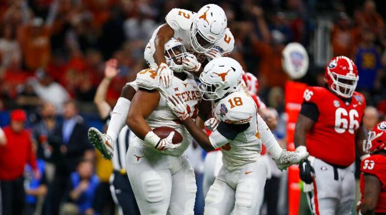 Texas defensive lineman Gerald Wilbon (94) celebrates his fumble recovery with defensive backs Kris Boyd (2) and Davante Davis (18) during the first half of the Sugar Bowl in New Orleans, Tuesday, Jan. 1, 2019.