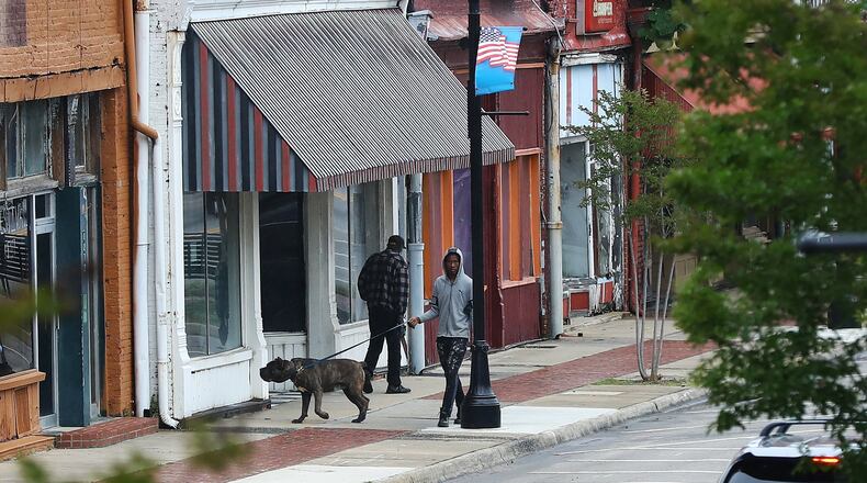 Residents walk past businesses, many of which are empty, on West Broad Street in downtown Sparta on Wednesday. Hancock County, halfway between Augusta and Macon, has become a new coronavirus hot spot. (PHOTO by Curtis Compton ccompton@ajc.com)