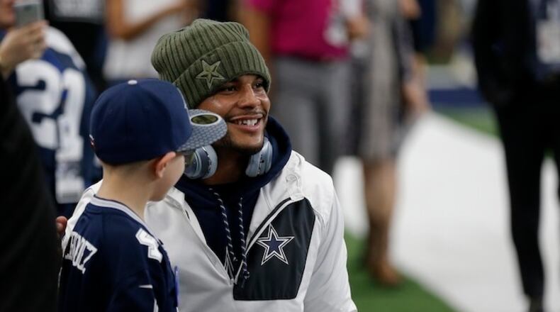 Dallas Cowboys' Dak Prescott poses for a photo with a young fan before an NFL football game against the Kansas City Chiefs on Sunday, Nov. 5, 2017, in Arlington, Texas. (AP Photo/Brandon Wade)