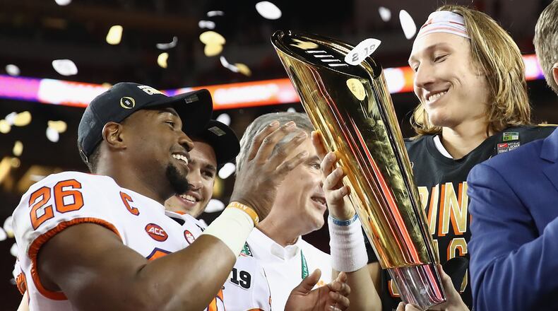 Adam Choice #26 and Trevor Lawrence #16 of the Clemson Tigers celebrate with the trophy after their teams 44-16 win over the Alabama Crimson Tide in the CFP National Championship presented by AT&T at Levi's Stadium on January 7, 2019 in Santa Clara, California. (Photo by Ezra Shaw/Getty Images)