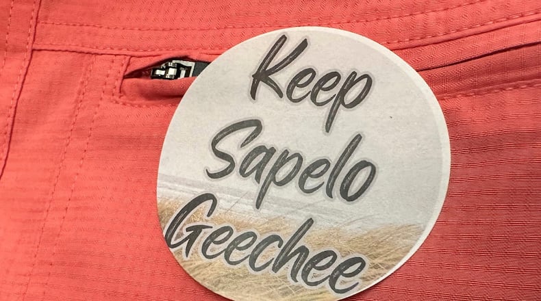 A sticker saying "Keep Sapelo Geechee" is worn on the shirt of George Grovner, a resident of the Hog Hummock community on Sapelo Island, during a meeting earlier this month of the of McIntosh County Commission in Darien. Commissioners voted to double the maximum size of homes allowed in the tiny community of people known as Gullah Geechee, who are descended from enslaved people who worked coastal plantations. Residents say they fear the zoning change will raise their property values and taxes, potentially forcing them to sell their land. (AP Photo/Ross Bynum)