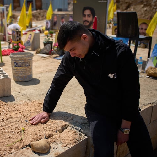 Ahmad Assi, 29, cries on the grave of his friend Hassan Ali Badawi, a paramedic of the Lebanese Red Cross killed in a Israeli strike, during his funeral in Choueifat, Lebanon, Monday, April 13, 2026. (AP Photo/Emilio Morenatti)