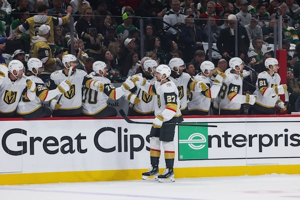 Vegas Golden Knights defenseman Shea Theodore (27) high-fives teammates after scoring a goal against the Minnesota Wild during the first period in Game 4 of an NHL hockey Stanley Cup first-round playoff series, Saturday, April 26, 2025, in St. Paul, Minn. (AP Photo/Stacy Bengs)
