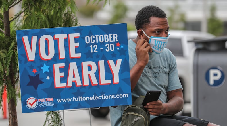 October 12, 2020 Atlanta: Cadarius Parks made it through the line and voted on Monday, Oct. 12, 2020 at State Farm Arena in downtown Atlanta. Eager Georgia voters swarmed to polling places Monday morning, waiting in lines created by high turnout and technical problems at the start of three weeks of early voting before Election Day. A glitch with voter check-in computers held up voters at Georgia’s largest early voting site at State Farm Arena. Lines stopped after voters received an “invalid card” error when inserting green voter access cards into touchscreens. Poll workers had to reboot the arena’s 60 voter check-in tablets and re-import voter information, said Fulton Elections Director Richard Barron. “We apologize to all the voters,” Barron said. (John Spink / John.Spink@ajc.com)