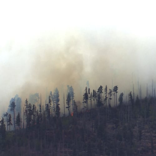 Smoke rises after a small medical plane crashed in a mountain range outside Ruidoso, New Mexico, on Thursday, May 14, 2026. (KOAT via AP)