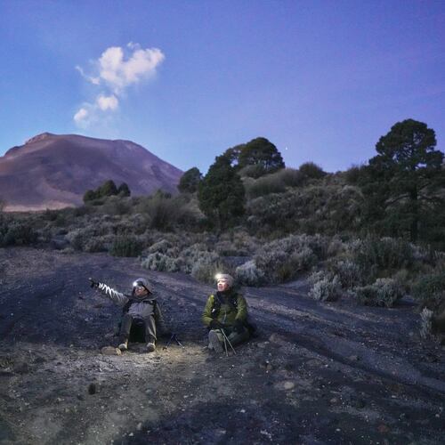 Marco Calo, left, a geophysicist at the National Autonomous University of Mexico (UNAM), take a break on the slopes of the Popocatepetl volcano in Mexico, Friday, Dec. 5, 2025. (AP Photo/Eduardo Verdugo)
