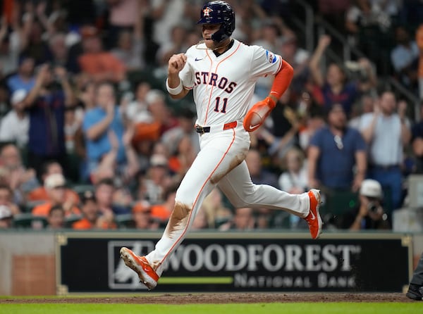 Houston Astros' Cam Smith (11) scores a run on Mauricio Dubon's RBI single against the Tampa Bay Rays during the fifth inning of a baseball game, Thursday, May 29, 2025, in Houston. (AP Photo/Karen Warren)