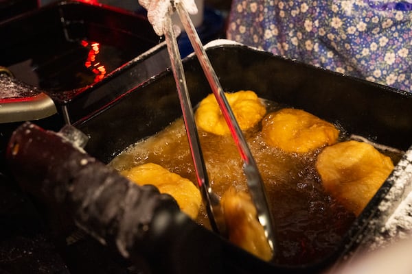 Vendors make traditional frybread topped with venison, beans and shredded cheese at the "Art of Activism" at 7 Stages Theatre in Atlanta on Friday, Nov. 14, 2025. This event marks the beginning of several weekends of festivities for the First Voices Festival, a celebration of Indigenous cultures (Olivia Bowdoin for the AJC)