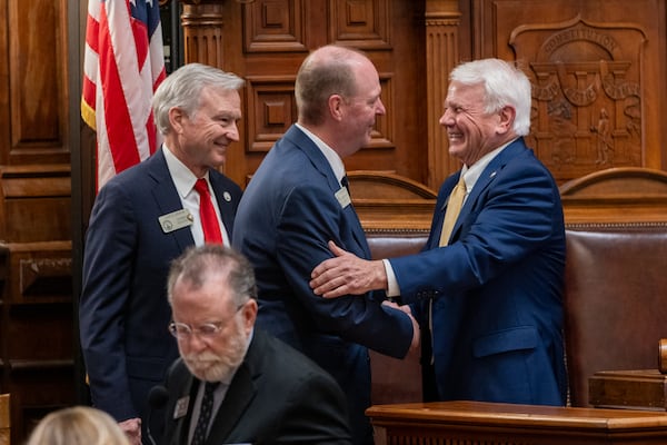Rep. Holt Persinger (center), R-Winder, shakes hands with House Speaker Jon Burns, R-Newington, following the passage of HB 268 — a school safety bill that Persinger sponsored — at the Capitol on March 4, 2025, in Atlanta. (Arvin Temkar/AJC)