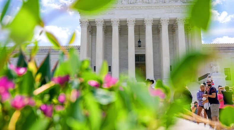 Visitors walk in front of the Supreme Court Friday, July 24, 2026, in Washington. (AP Photo/Mariam Zuhaib)