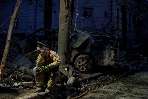 A rescue worker rests near university building destroyed by a Russian missile strike on Sumy, Ukraine, Sunday, April 13, 2025. (AP Photo/Evgeniy Maloletka)