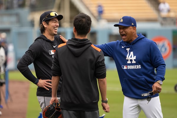 Detroit Tigers' Kenta Maeda, left, talks to Los Angeles Dodgers manager Dave Roberts before the Dodgers' home-opening baseball game in Los Angeles, Thursday, March 27, 2025. (AP Photo/Kyusung Gong)