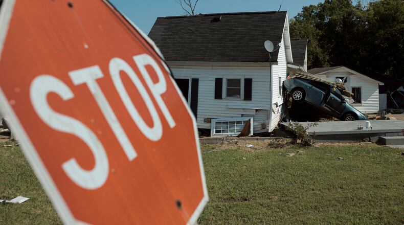 A vehicle rests against a house Tuesday in Waverly, Tennessee, after flash floods struck the region over the weekend. The search teams from across Tennessee that have descended on Humphreys County were pushing forward with urgency Tuesday to find those whose whereabouts remained unknown. (Brett Carlsen/The New York Times)