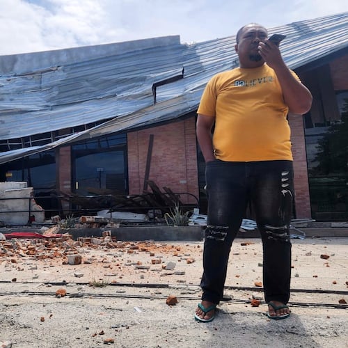 A man talks on his mobile phone near a building damaged in an earthquake in Palu, Central Sulawesi, Tuesday, June 16, 2026. (AP Photo/Josua Marunduh)