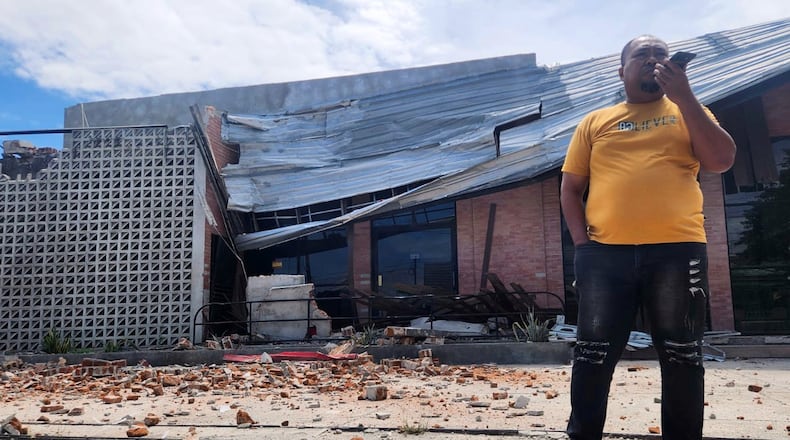 A man talks on his mobile phone near a building damaged in an earthquake in Palu, Central Sulawesi, Tuesday, June 16, 2026. (AP Photo/Josua Marunduh)